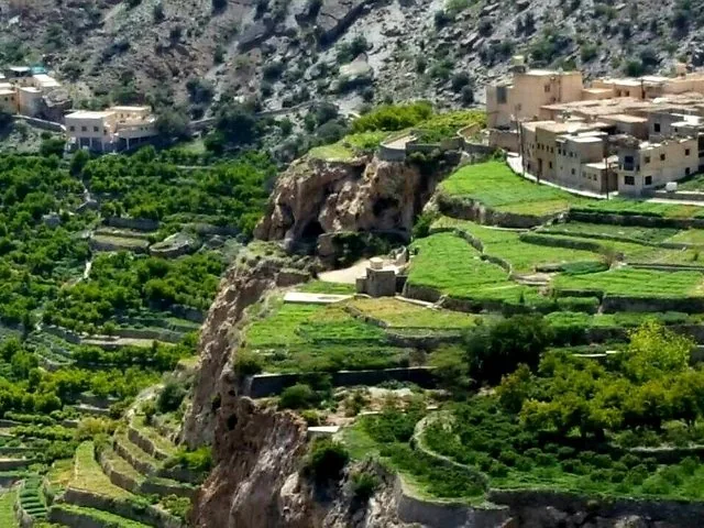Grüne Terrassenfelder und in die Berglandschaft gehauene Gebäude