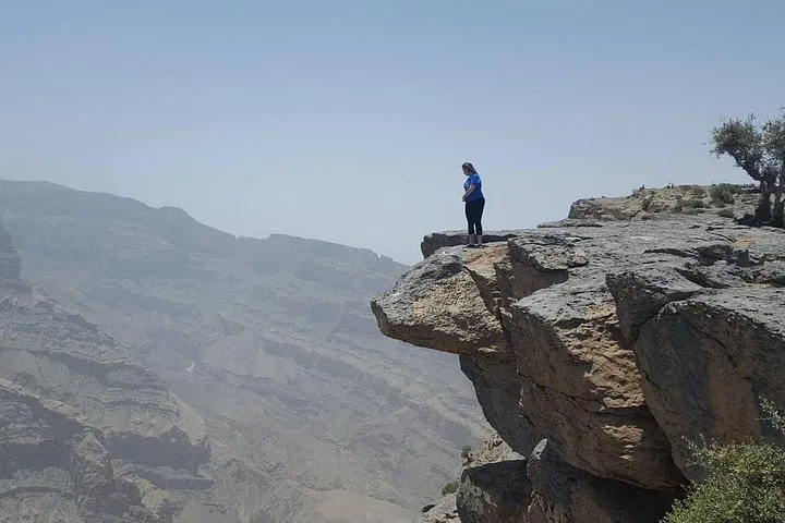 Person am Rand einer Felsklippe mit Blick auf den Canyon